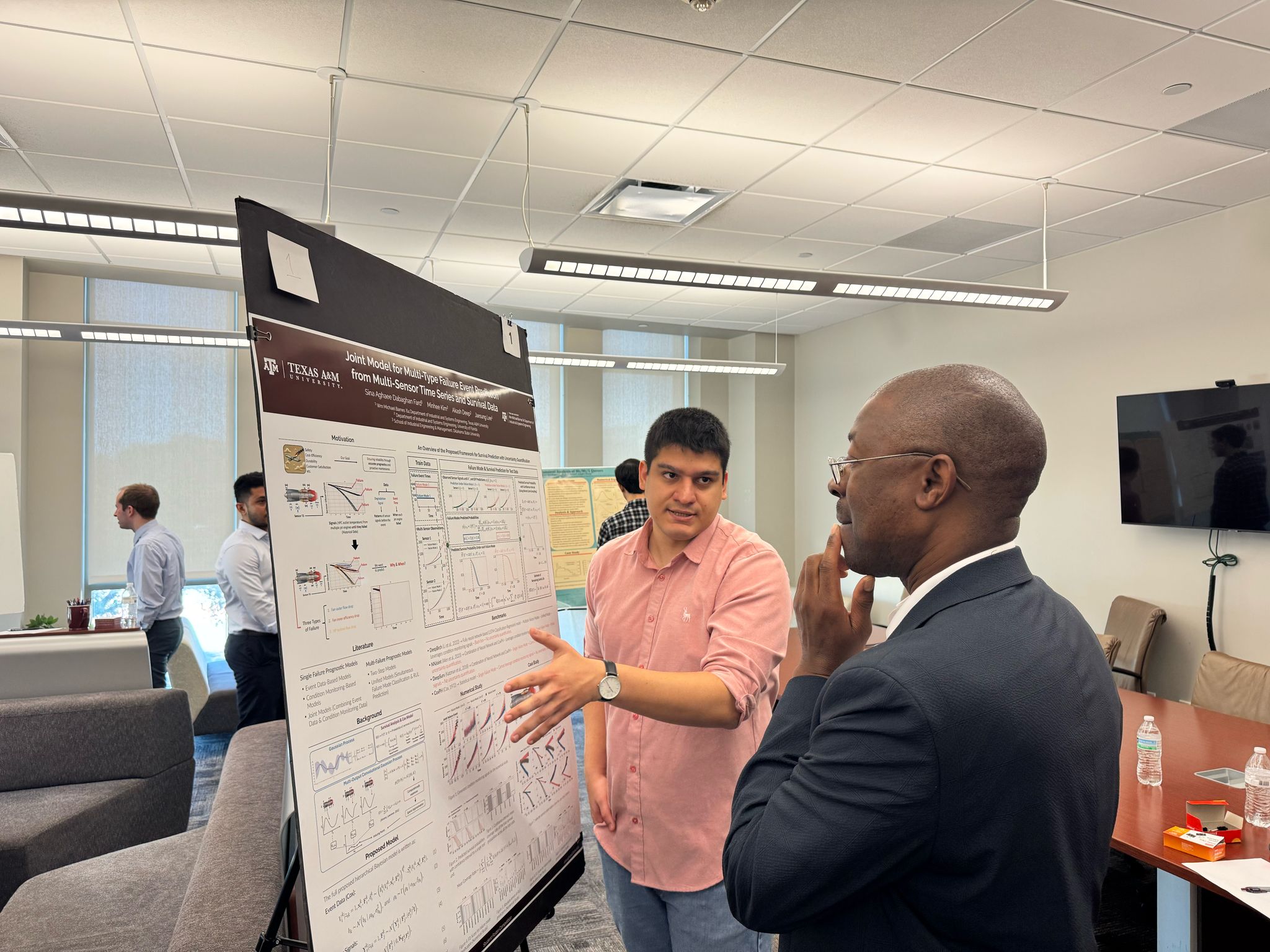 Sina Aghaee Dabaghan Fard discussing his poster with Lewis Ntaimo at the Texas A and M ISEN Poster Competition.
